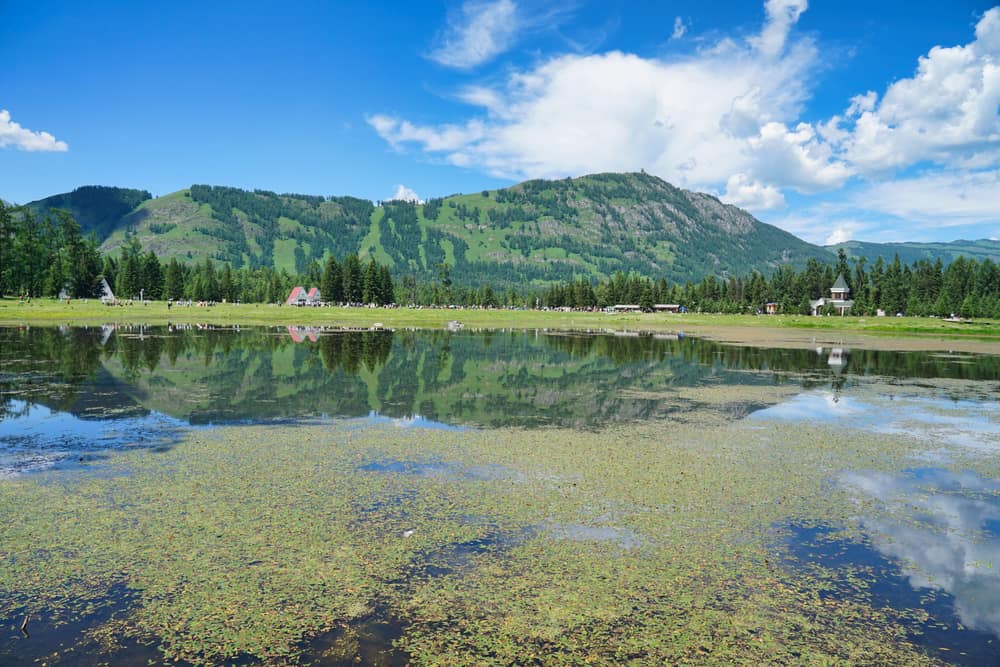 A mountain lake reflecting blue sky and green hills