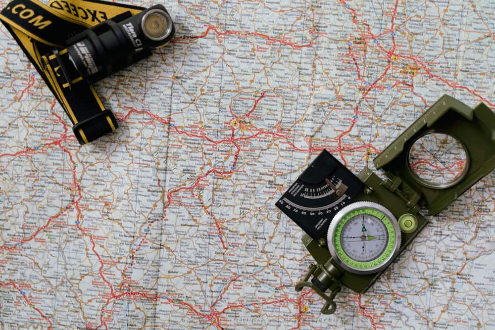 A paper map with a compass and flashlight