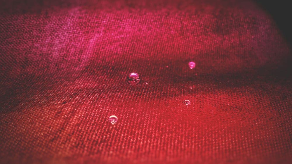 Close-up of water droplets beading on red fabric