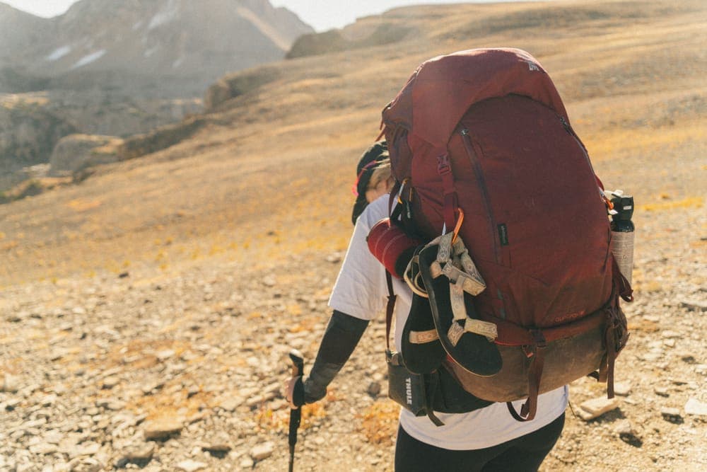 Illustrative stock photo: a backpacker with a loaded pack on a mountain trail