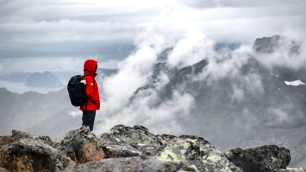 Illustrative stock photo: a hiker standing on a misty mountaintop
